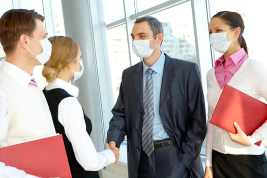 Portrait of successful partners in protective masks handshaking