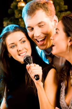 Portrait of three attractive friends singing together