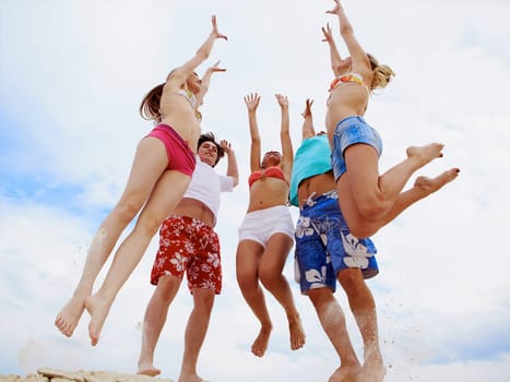 Photo of five friends in jump over sandy shore