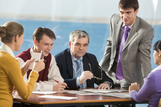 Several employees voicing their ideas to senior boss in office