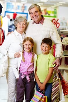 Portrait of happy grandparents and grandchildren during shopping