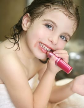 Little girl playing with lipstick makeup on the bathroom