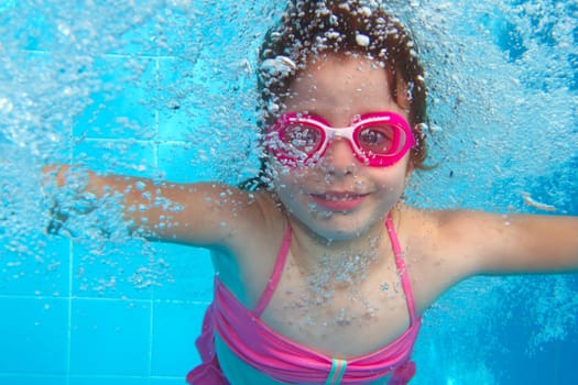 underwater little girl pink bikini goggles blue swimming pool