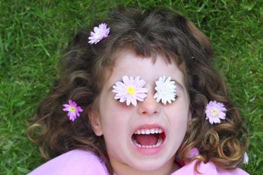 little girl laying grass daisy flowers in eyes