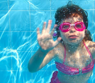 underwater little girl pink bikini goggles blue swimming pool