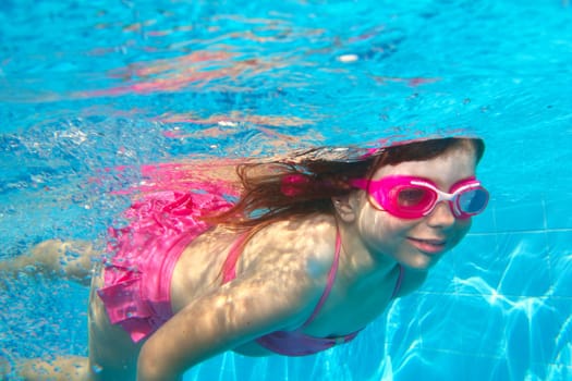 underwater little girl pink bikini goggles blue swimming pool