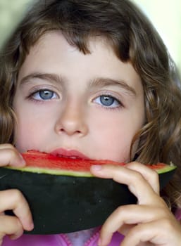 closeup little girl portrait eating watermelon slice blue eyes