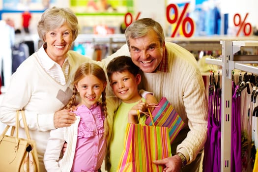 Portrait of happy grandparents and grandchildren during shopping