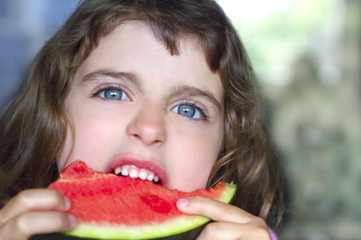closeup little girl portrait eating watermelon slice blue eyes