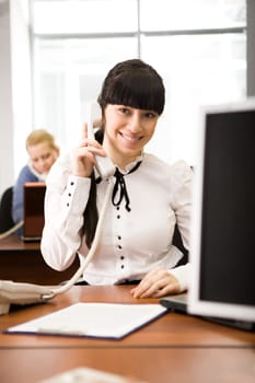 Pretty secretary speaking on the phone in the office