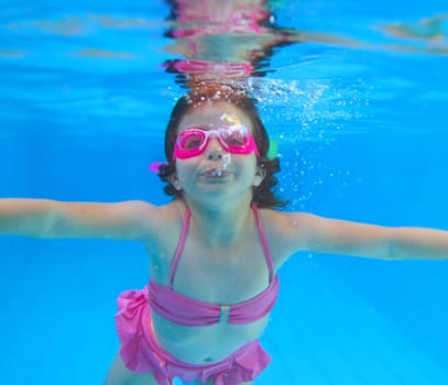 underwater little girl pink bikini goggles blue swimming pool