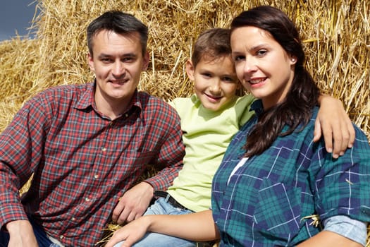 Happy family of three having rest in countryside