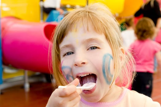 eating spoon funny girl playground smiling blond open mouth