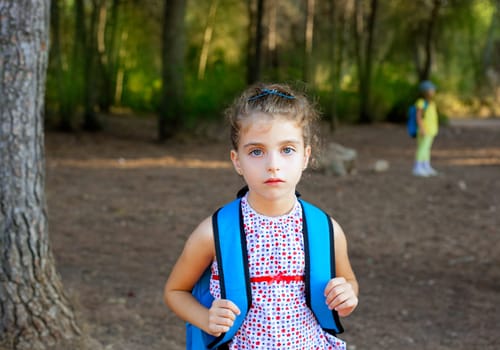 Children girl hiking with backpack in autumn forest