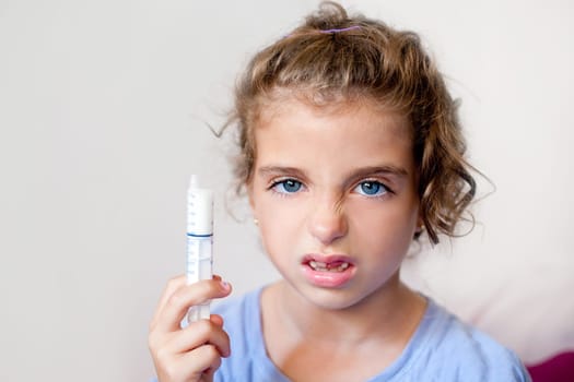 Unhappy kid girl with syringe medicine dose funny expression
