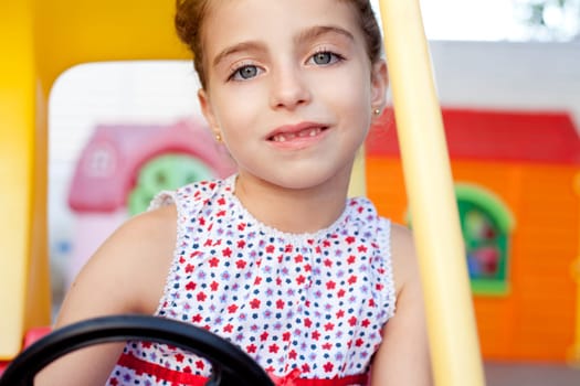 children girl driving a toy car in playground