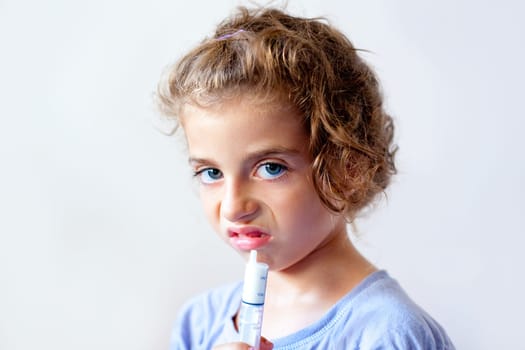 Unhappy kid girl with syringe medicine dose funny expression