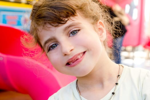 brunette indented girl with blue eyes smiling in red playground