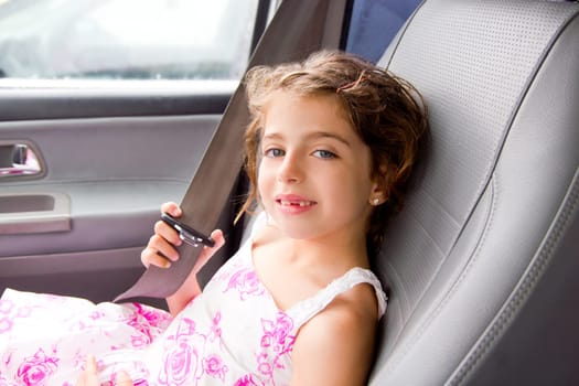 child little girl indoor car putting safety belt smiling