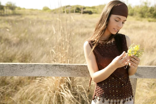 Beautiful woman in golden outdoor with yellow flower