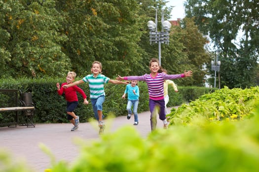 Portrait of happy friends running in park