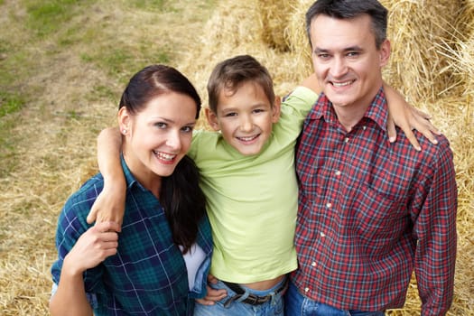 Happy family of three having rest in countryside