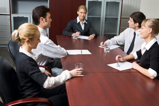 Team of successful business people are sitting at the table and discussing