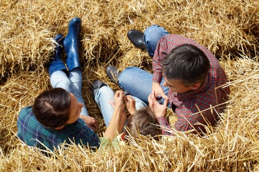 Above angle of family of three having rest in countryside