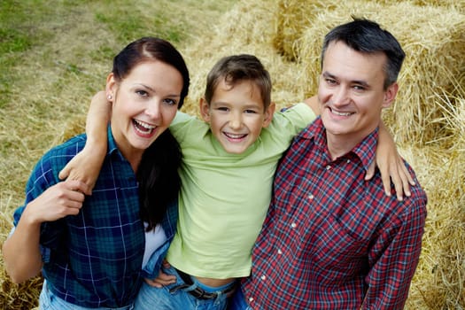 Happy family of three having rest in countryside