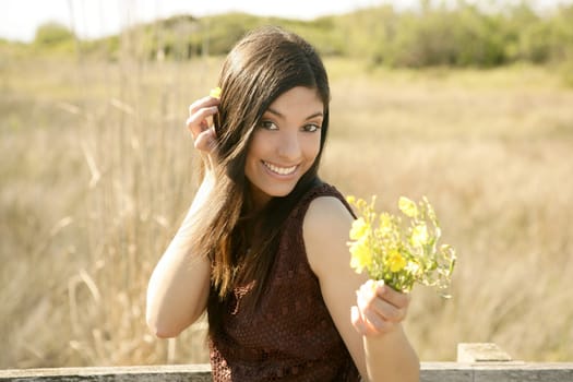 Beautiful woman in golden outdoor with yellow flower