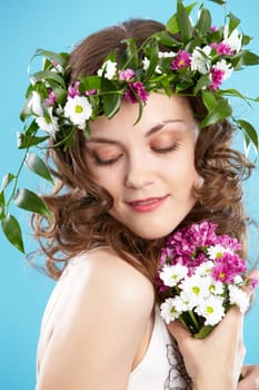 Beautiful woman in floral wreath looking aside
