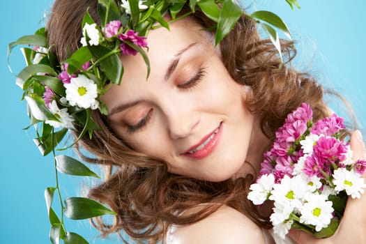 Beautiful woman in floral wreath looking aside