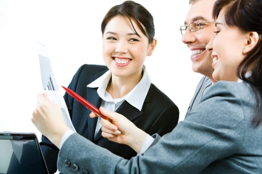 Portrait of businesswoman with paper in hands and pointing at the document while her colleague looking at it