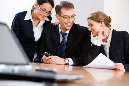 Image of three specialists in suit interacting with each other in the office