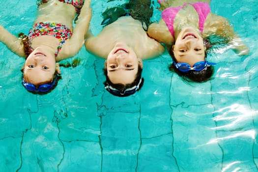 Photo of happy friends looking at camera in pool