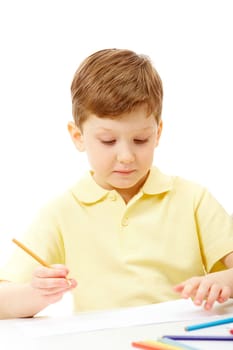 Portrait of young boy holding pencil and looking at the paper