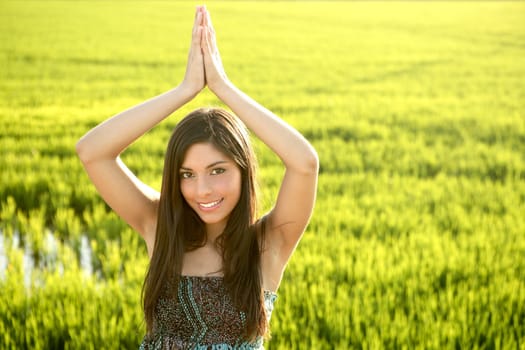 Beautiful brunette indian young woman in the green rice fields meadow
