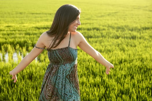 Beautiful brunette indian young woman in the green rice fields meadow