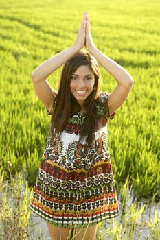 Beautiful brunette indian young woman in the green rice fields meadow