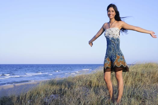 Beautiful brunette posing free with sunset sun on the beach