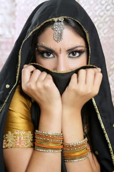 Beautiful brunette asian girl with black veil on face, traditional indian costume