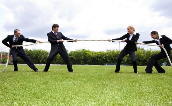 Photo of business people stretching the rope in the stadium