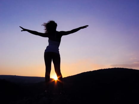 Photo of energetic female outline with stretched arms somewhere outside