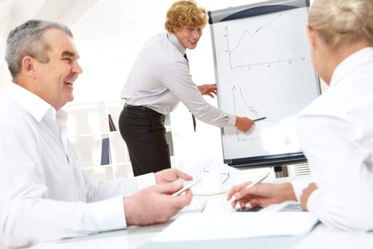 Photo of successful manager standing by whiteboard and explaining his ideas
