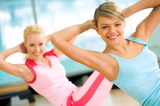 Photo of cheerful girl doing exercise on the floor of sport gym