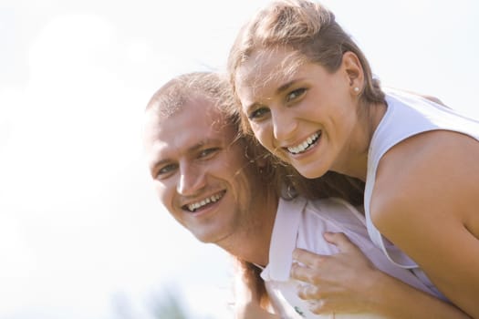Photo of happy girl embracing handsome guy against blue sky at summer