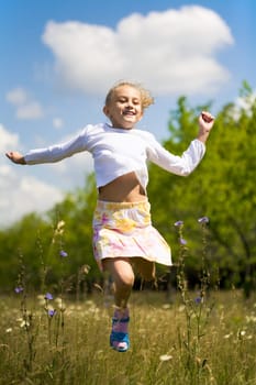 Portrait of joyful girl jumping high outdoors at summer