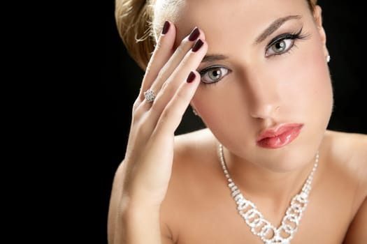 Blond elegant thinking fashion woman with jewelry on black