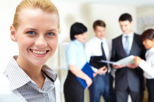 Image of pretty female looking at camera in working environment