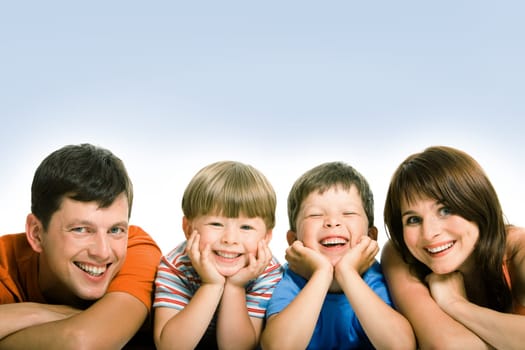 Line of mother, father and their two sons looking at camera with happy smiles